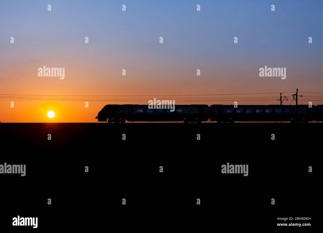 Virgin trains / Avanti West Coast 221 diesel voyager train sur la ligne principale électrifiée de la côte ouest, faisant une silhouette de coucher de soleil Banque D'Images