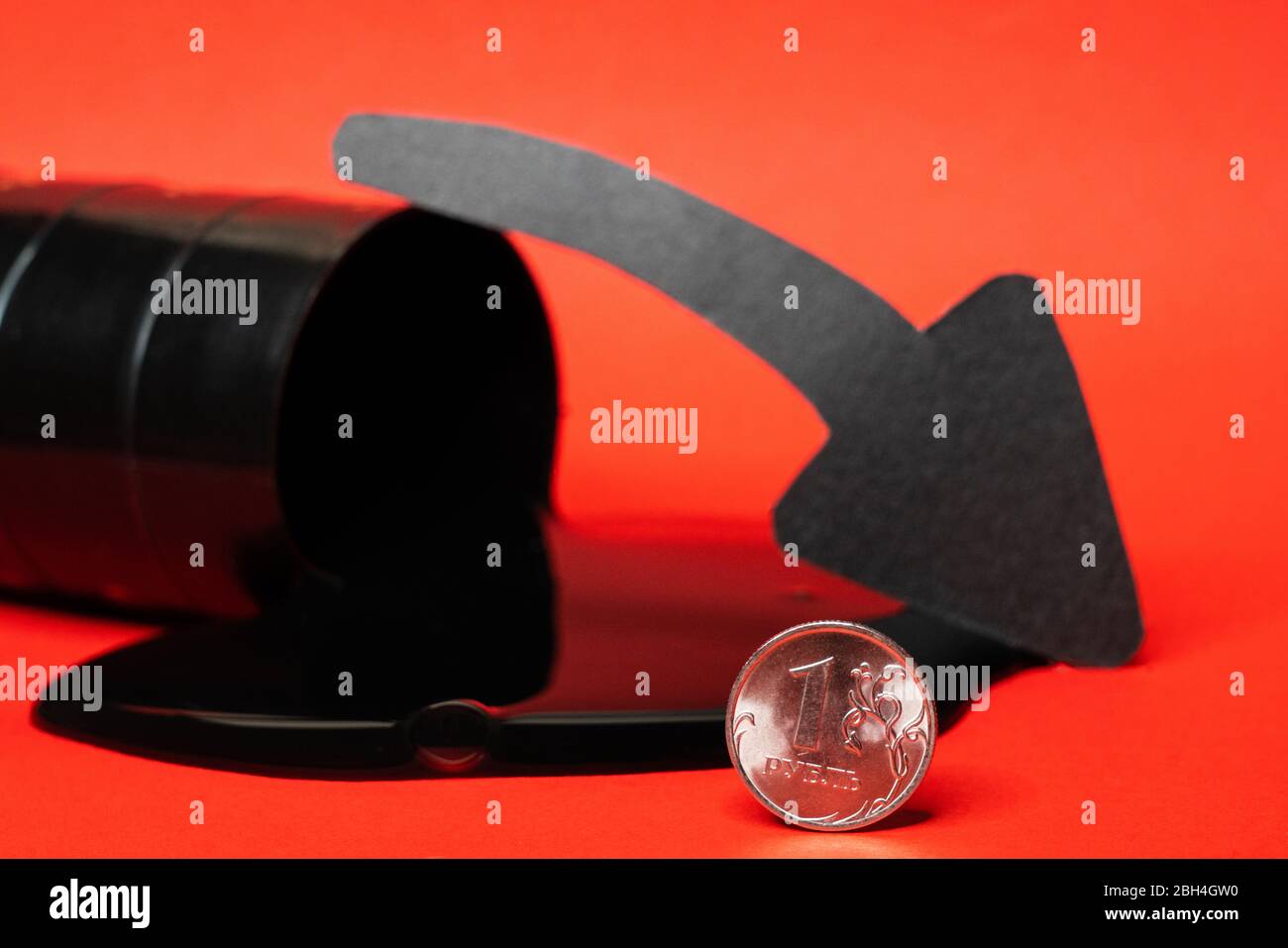 l'huile s'écoule du fourreau avec une pièce de monnaie à une pièce rouble et une flèche vers le bas sur un fond rouge. Le prix du baril de pétrole chute dans le tableau. Tendance du marché pétrolier. Pétrole Banque D'Images