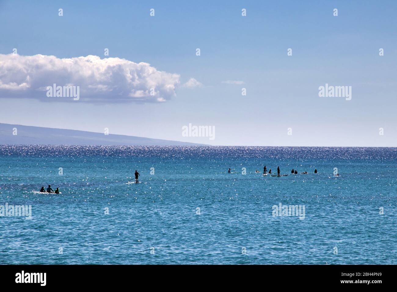 Surfeurs et pagayeurs non identifiables sur l'océan à Maui. Banque D'Images