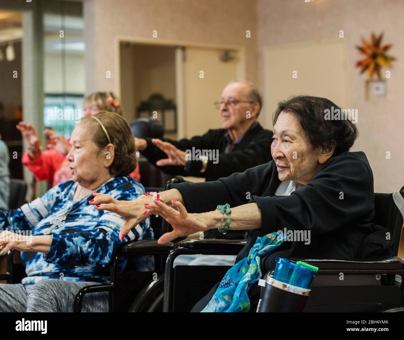 Personnes âgées s'étirant en fauteuil roulant Banque D'Images