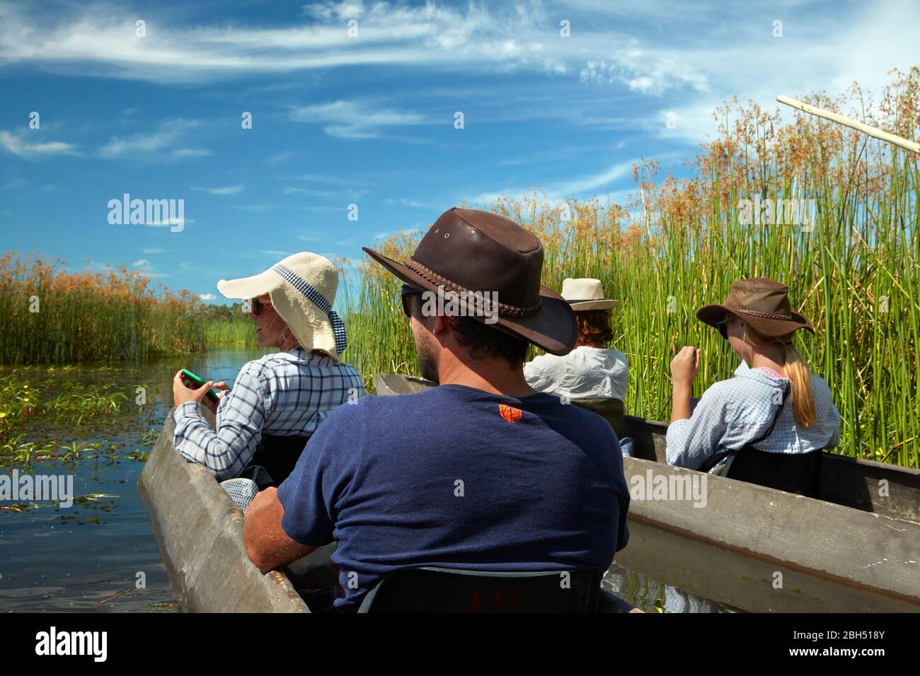 Touristes en train d'être polés dans mokoros (dugout canoes), dans le Delta d'Okavango, au Botswana, en Afrique Banque D'Images