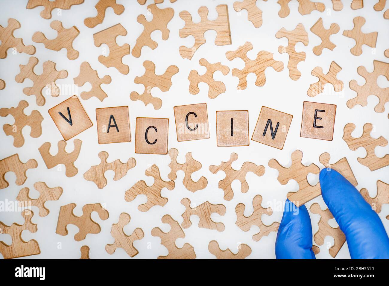 Vue aérienne de Jigsaw Puzzle pièces entourant les lettres carrelées orthographe du vaccin Word. Banque D'Images