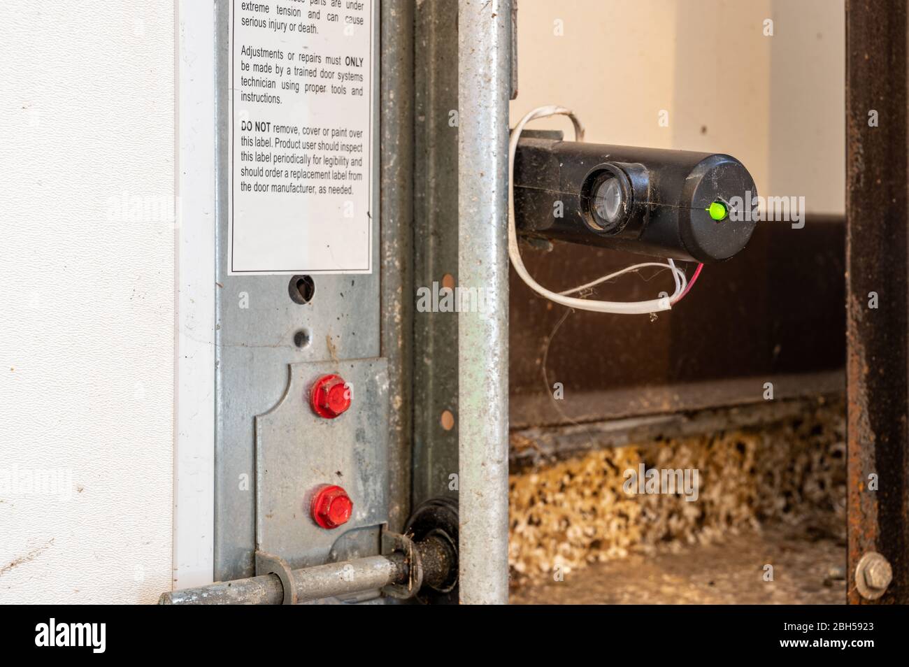 Un œil récepteur d'un capteur de sécurité de porte de garage qui arrête  l'action si le faisceau est traversé Photo Stock - Alamy