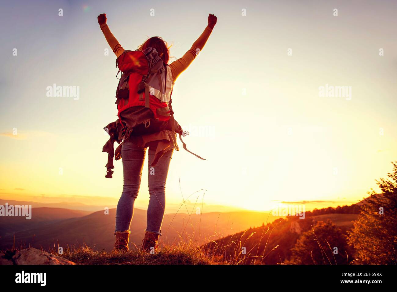 Cheering woman hiker bras ouverts au sommet de montagne Banque D'Images