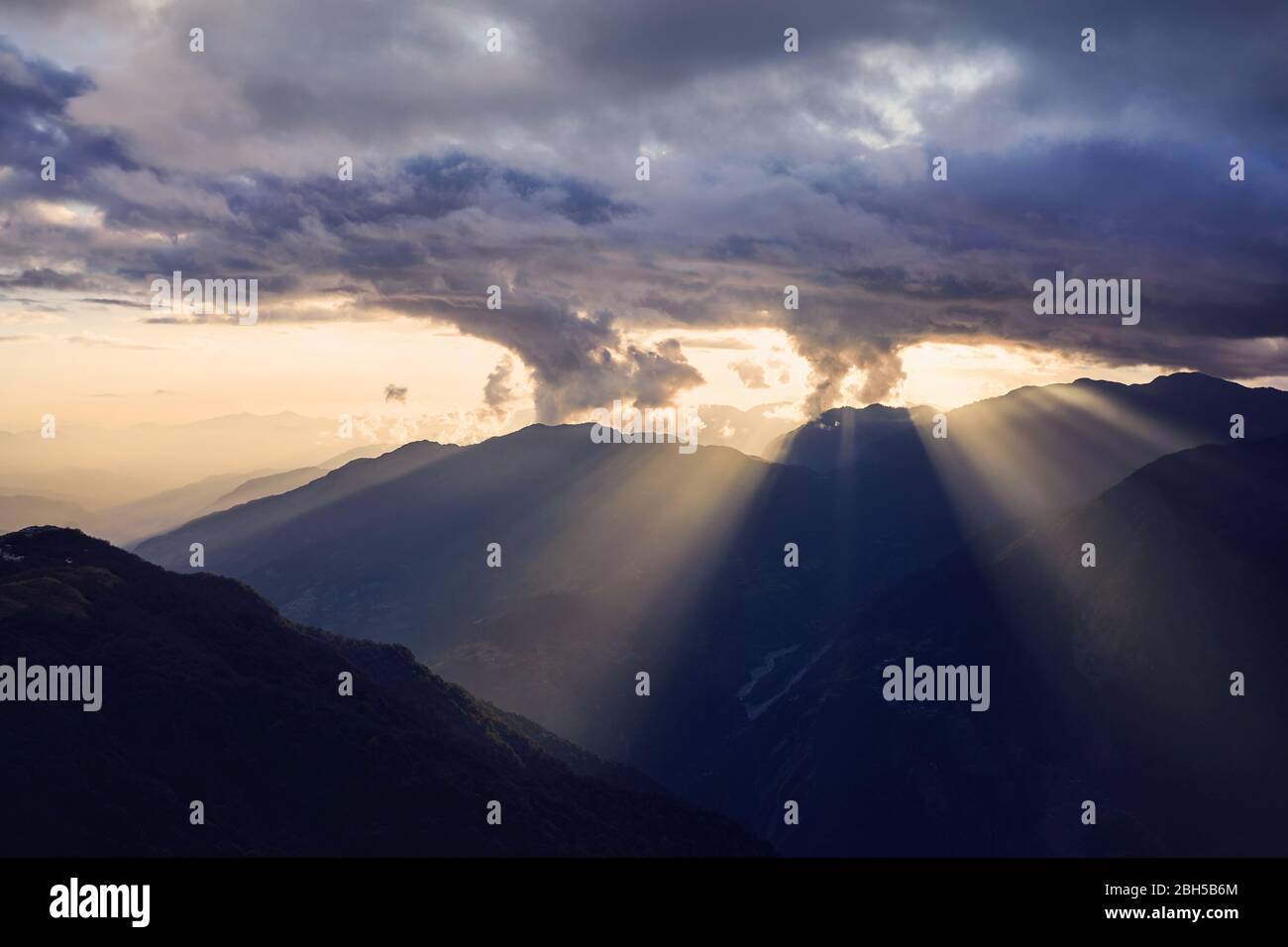 Sunet magnifique avec des nuages et des rayons de soleil au-dessus des collines de l'Himalaya au Népal Banque D'Images Sunet magnifique avec des nuages et des rayons de soleil au-dessus des collines de l'Himalaya au Népal Banque D'Images