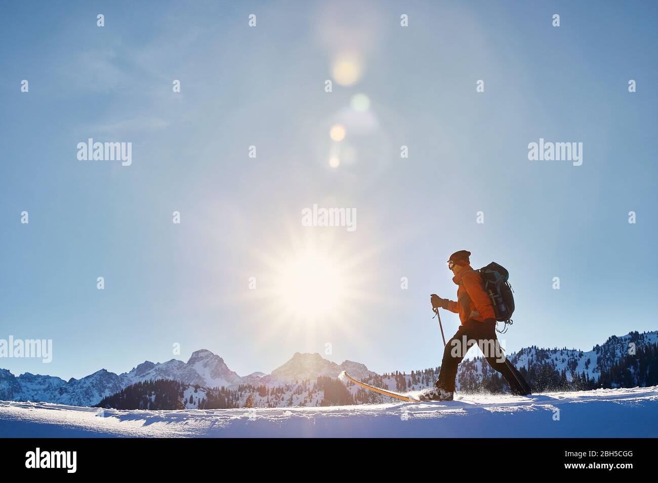 L'homme sur le ski de poudreuse la neige à la montagne contre ciel ensoleillé près d'Almaty, Kazakhstan Banque D'Images