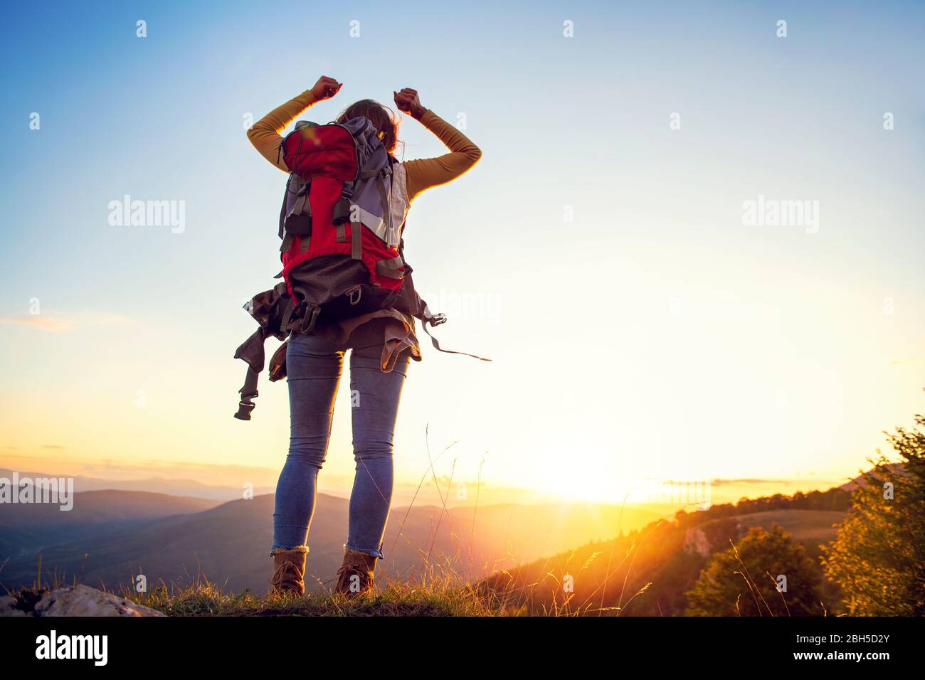Cheering woman hiker bras ouverts au sommet de montagne Banque D'Images