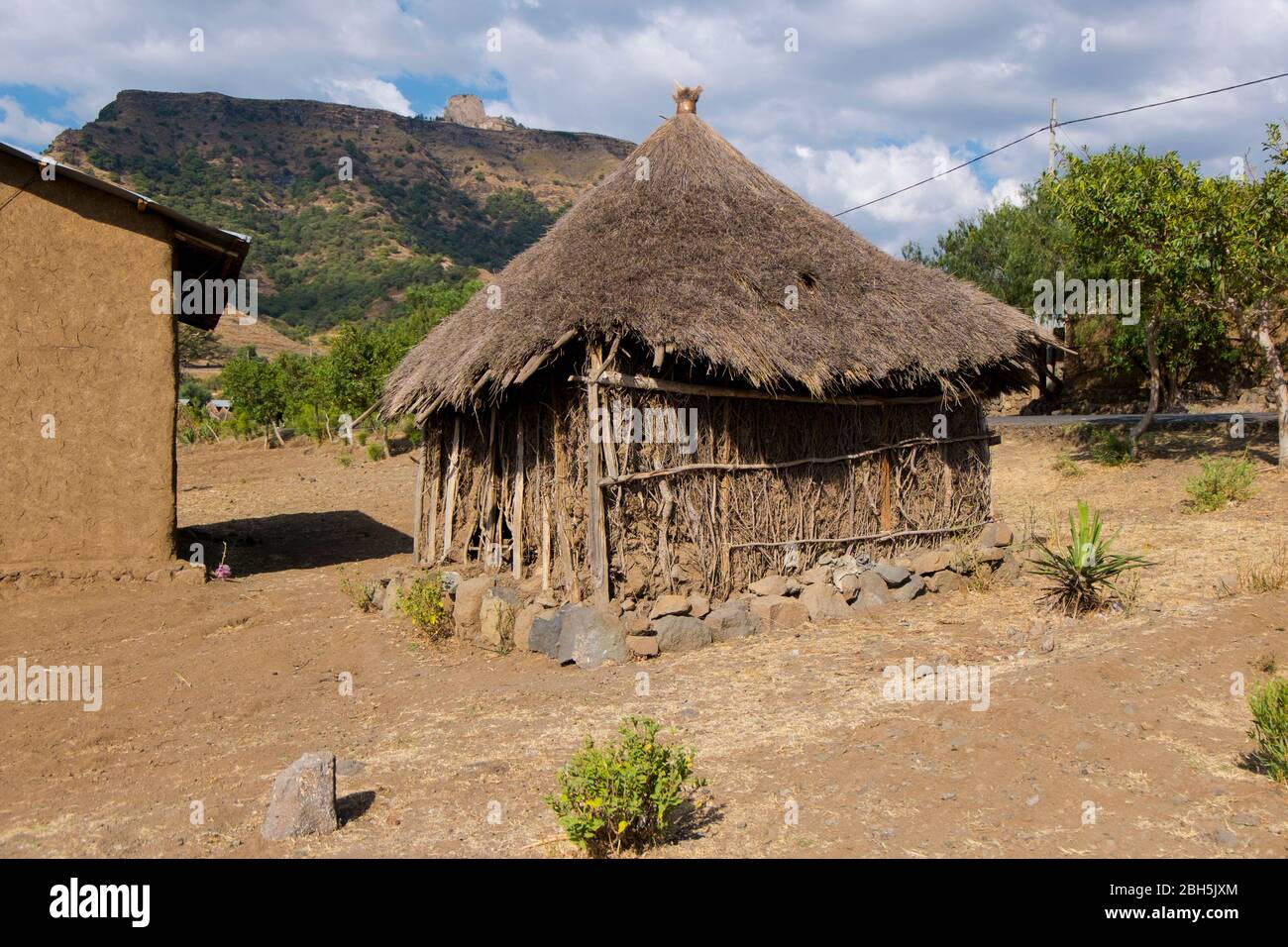 Une chaume typique, une cabane à bâton, une place avec une fondation en pierre. Dans les zones rurales de l'Ethiopie, en Afrique. Banque D'Images