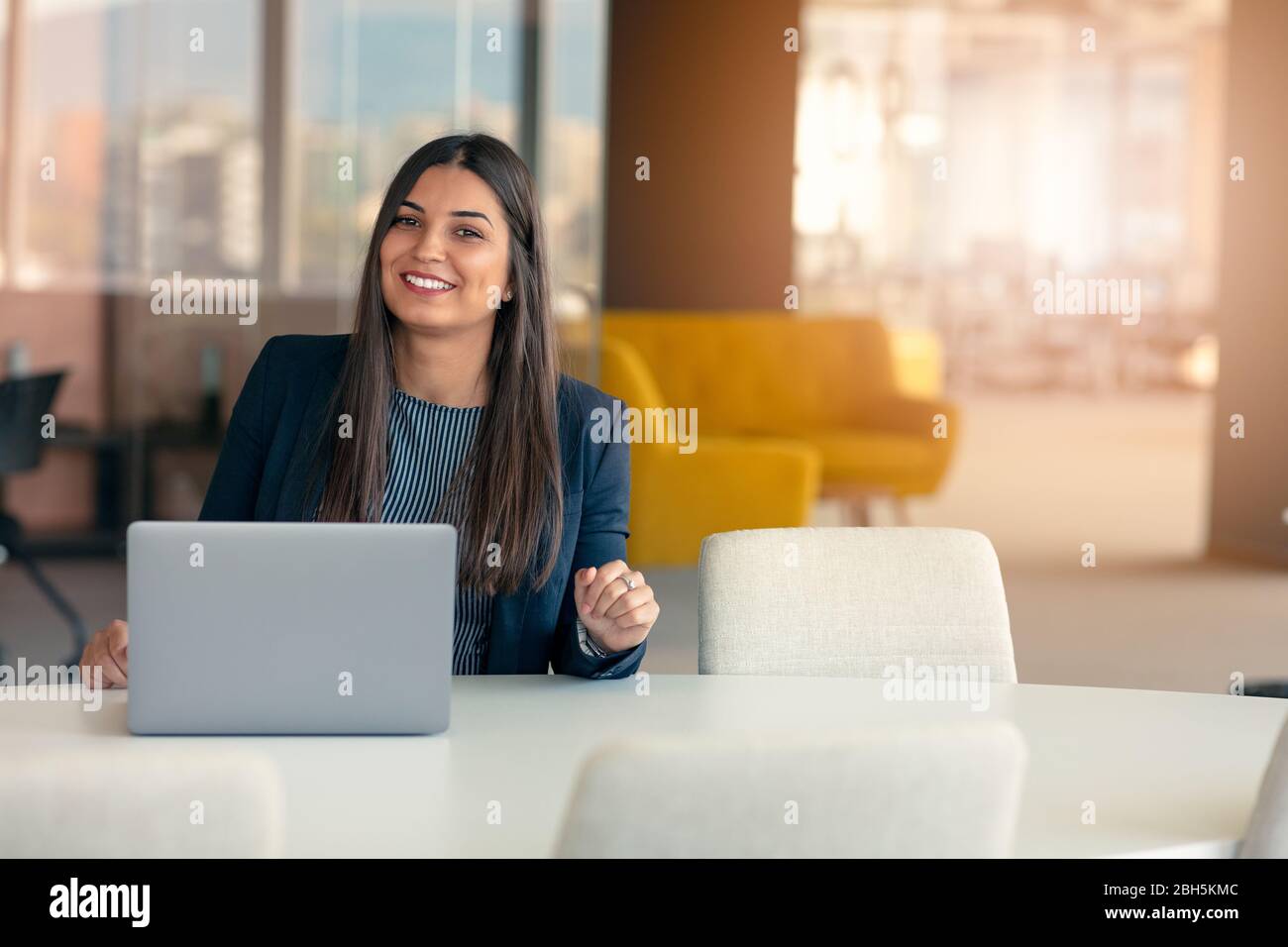 Jeune femme d'affaires souriante au travail dans un bureau moderne. Banque D'Images