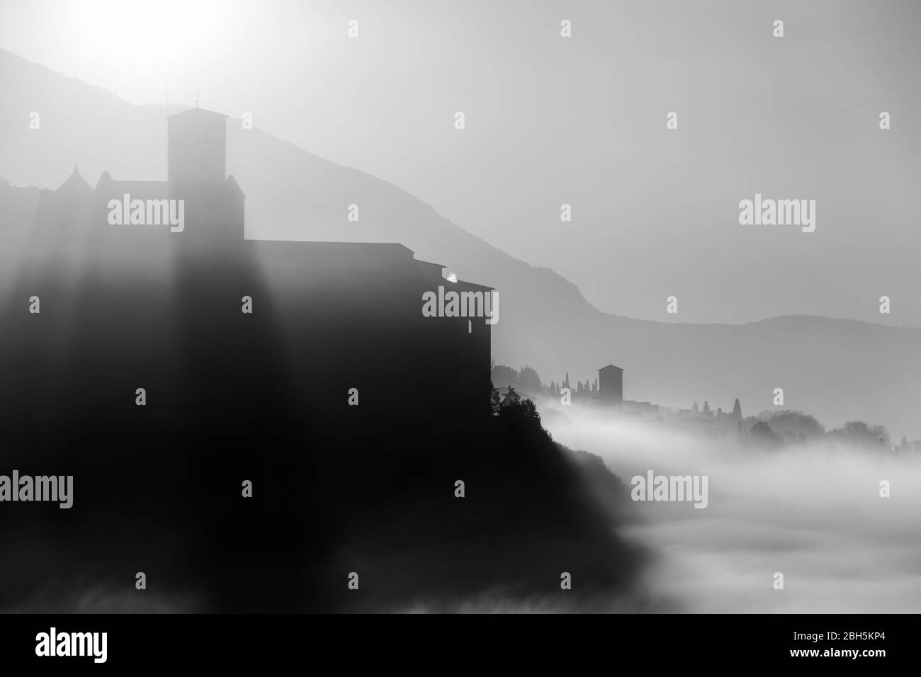 Vue surréaliste de l'église d'Assise et de Saint François (Ombrie, Italie) au milieu du brouillard à l'aube Banque D'Images