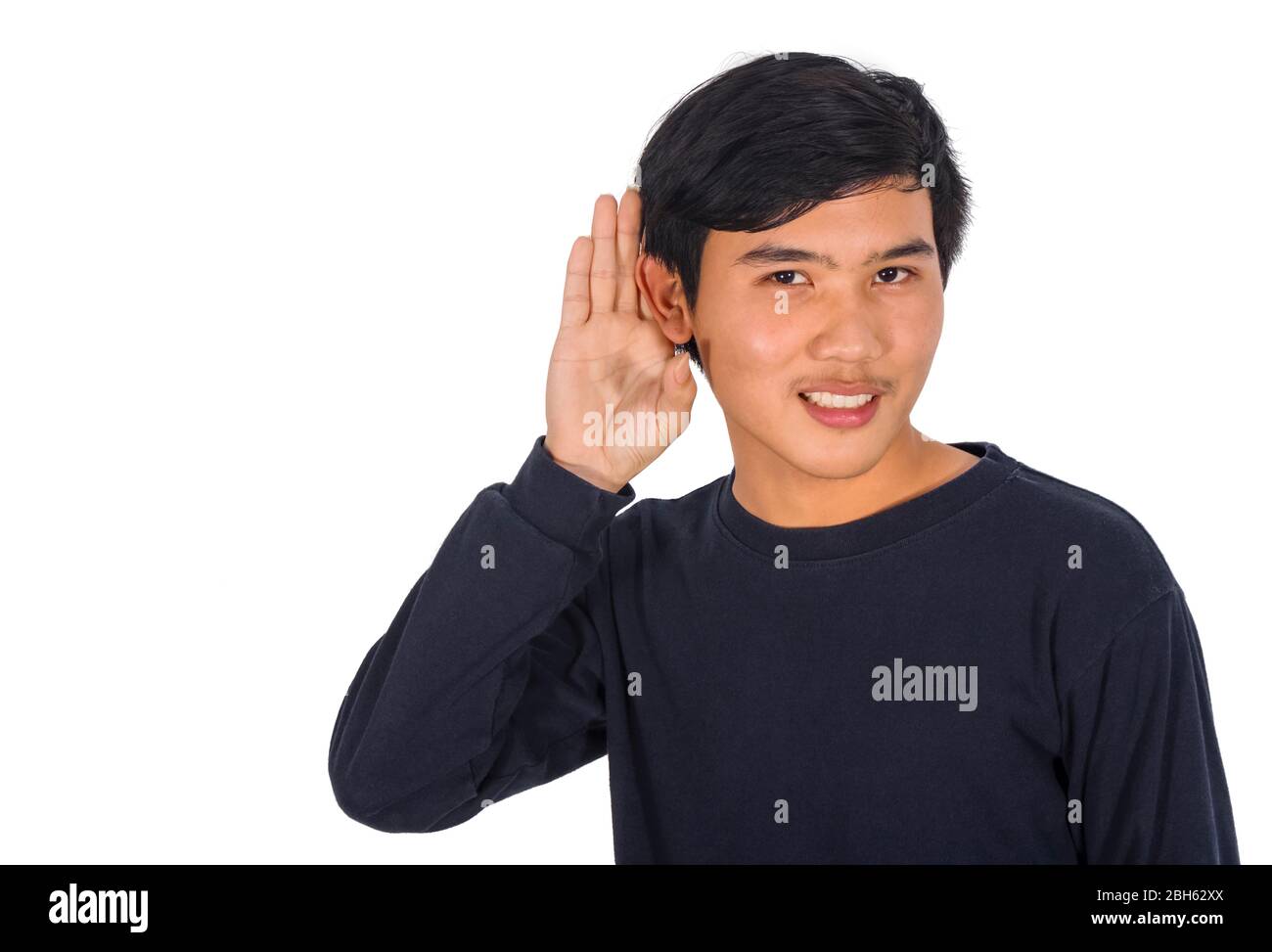 La photo d'un Asianman en chemise noire est couvrant son oreille gauche avec sa main. Banque D'Images