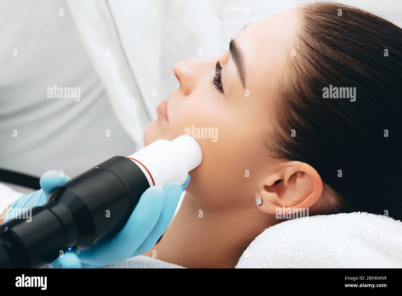Esthéticienne faisant des traitements de rides, thérapie acoustique d'ondes sur le visage. Face rapprochée Banque D'Images Esthéticienne faisant des traitements de rides, thérapie acoustique d'ondes sur le visage. Face rapprochée Banque D'Images