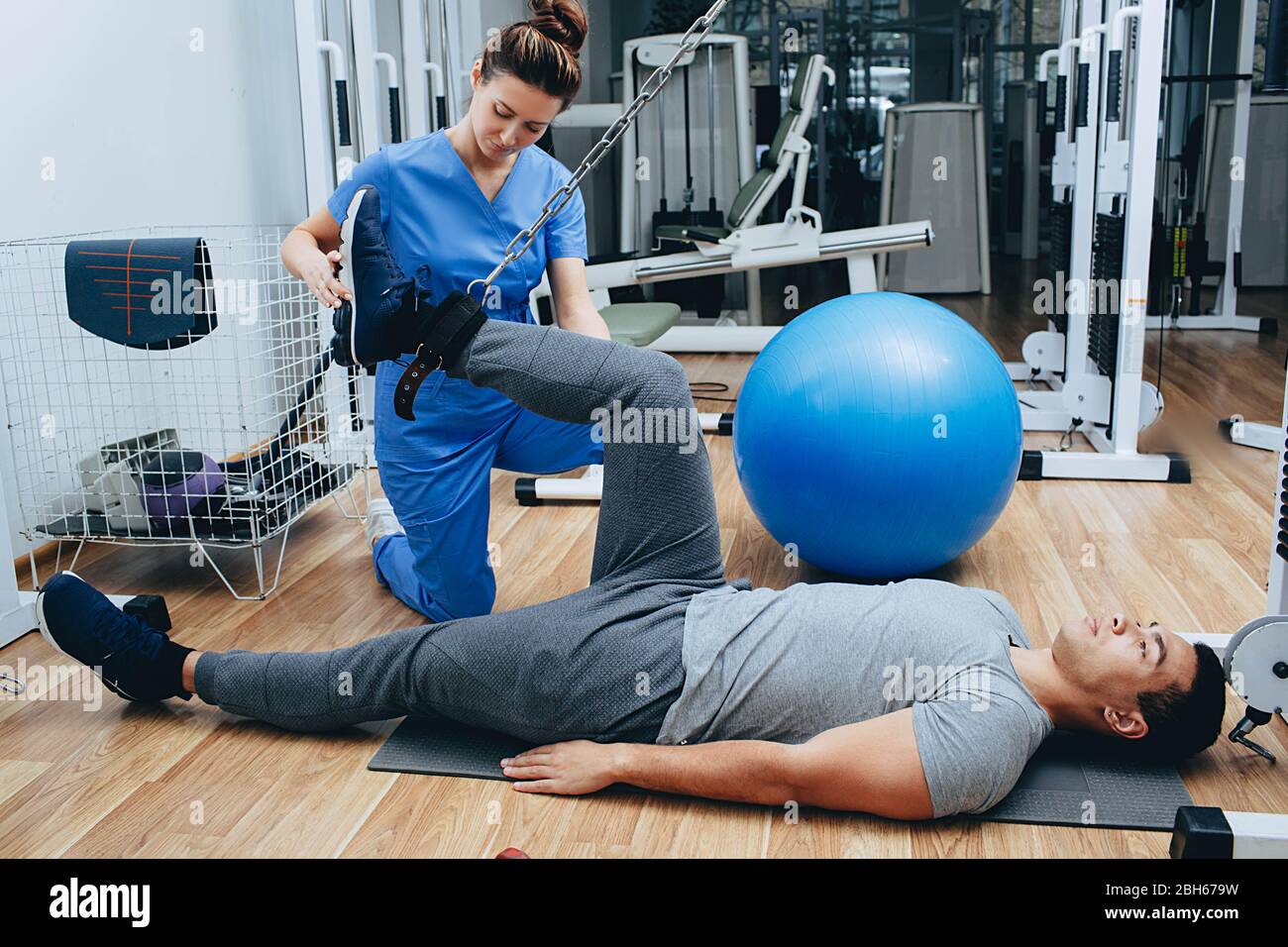 Entraînement de kinésithérapeute avec un patient masculin de race mixte. Le traitement de l'ostéondrite, de la douleur articulaire, des exercices de kinésithérapie Banque D'Images