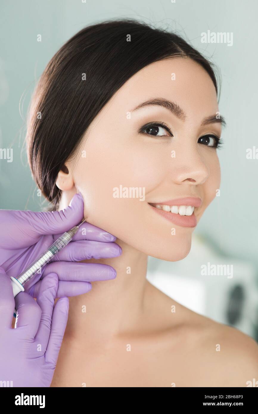 Belle femme asiatique obtient des injections de beauté. Close-up l'injection de rides et anti-âge visage féminin parfait Banque D'Images