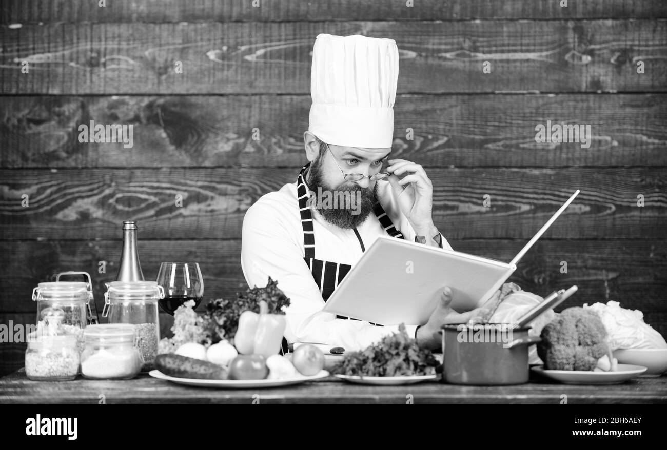 Suivez la recette. concentrés barbu la cuisson dans la cuisine. Suivre un régime d'aliments biologiques. Les légumes frais. La vitamine. man utiliser des ustensiles de cuisine. Chef professionnel en uniforme cook. L'alimentation saine et végétarienne. Banque D'Images