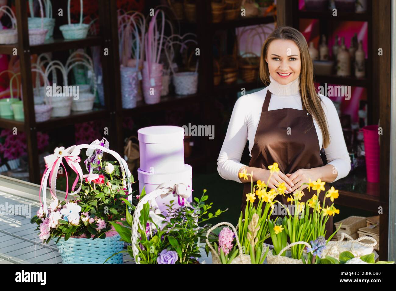 Propriétaire d'une boutique de fleur positive à la caméra et au sourire. Propriétaire de petite entreprise Banque D'Images