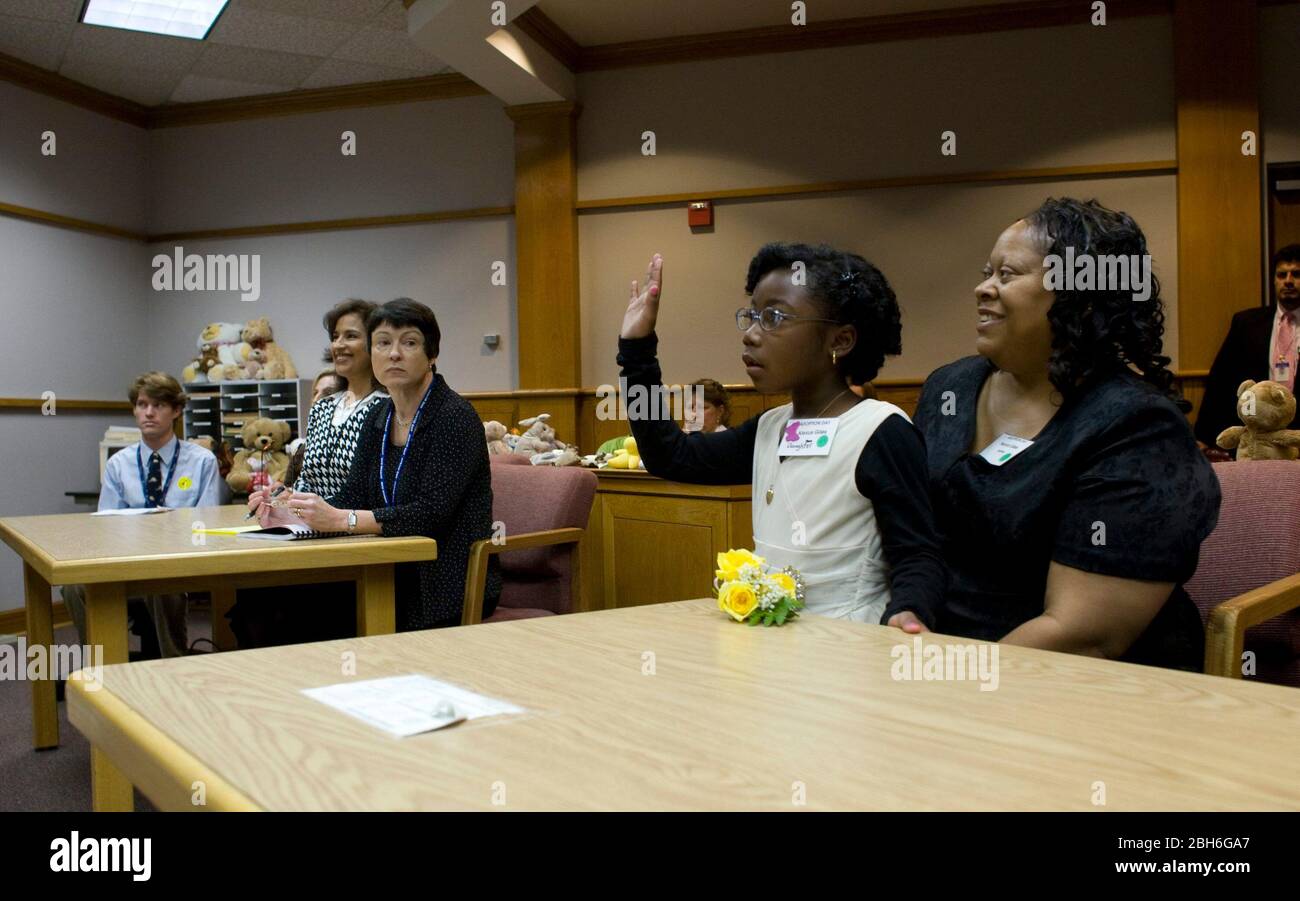 Austin, Texas, 20 novembre 2008 : la célébration de la Journée nationale d'adoption dans le centre du Texas a été de 24 familles qui ont adopté des enfants lors de cérémonies de fête à la cour Juvenile du comté de Travis. Alexus Giles (c) prête serment comme la mère Penora Giles (r) la tient. ©Bob Daemmrich Banque D'Images