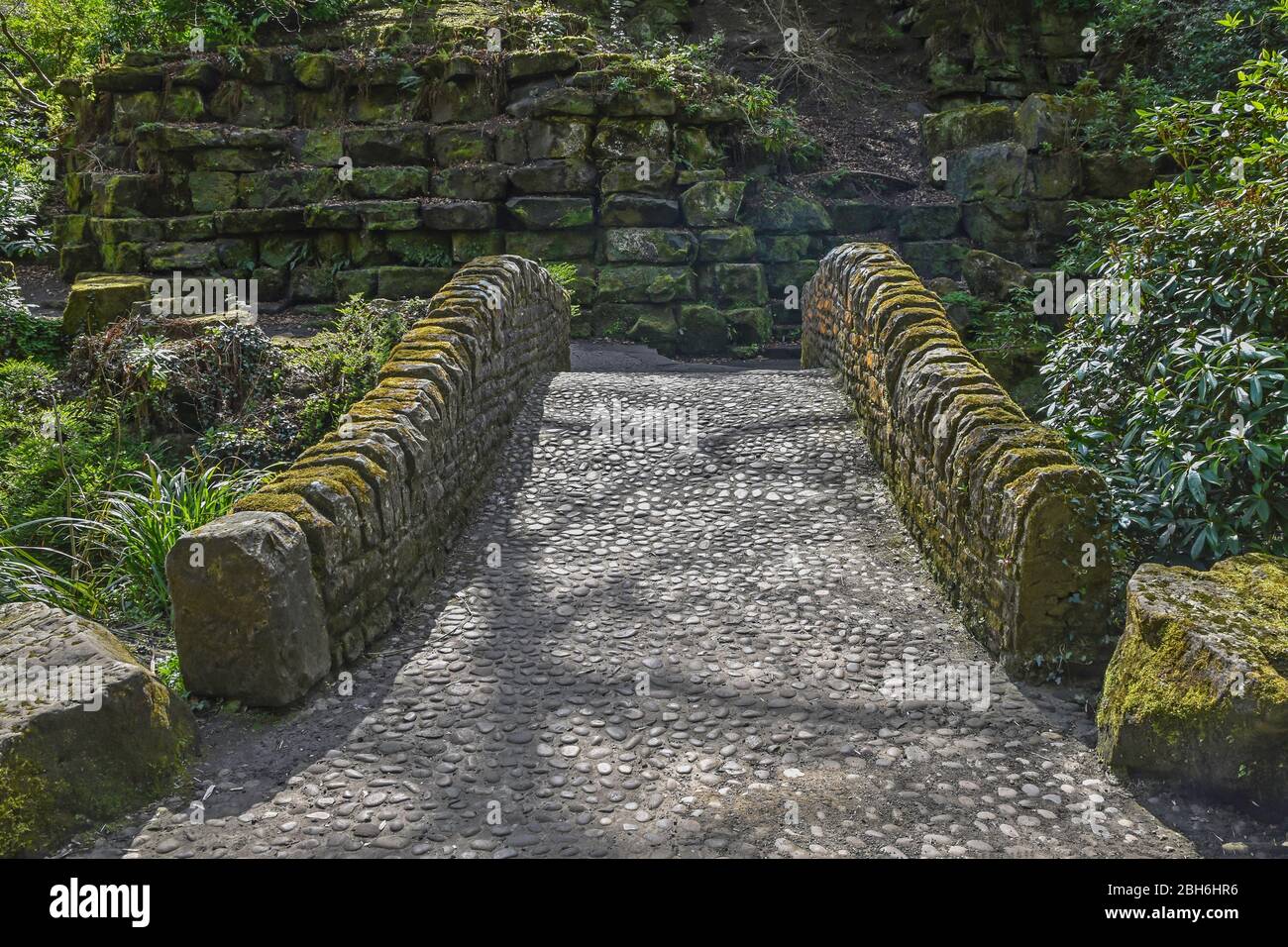 Vue symétrique du pont arqué avec chemin pavé dans le parc Pittencrieff, Dunfermline, Écosse, Royaume-Uni Banque D'Images