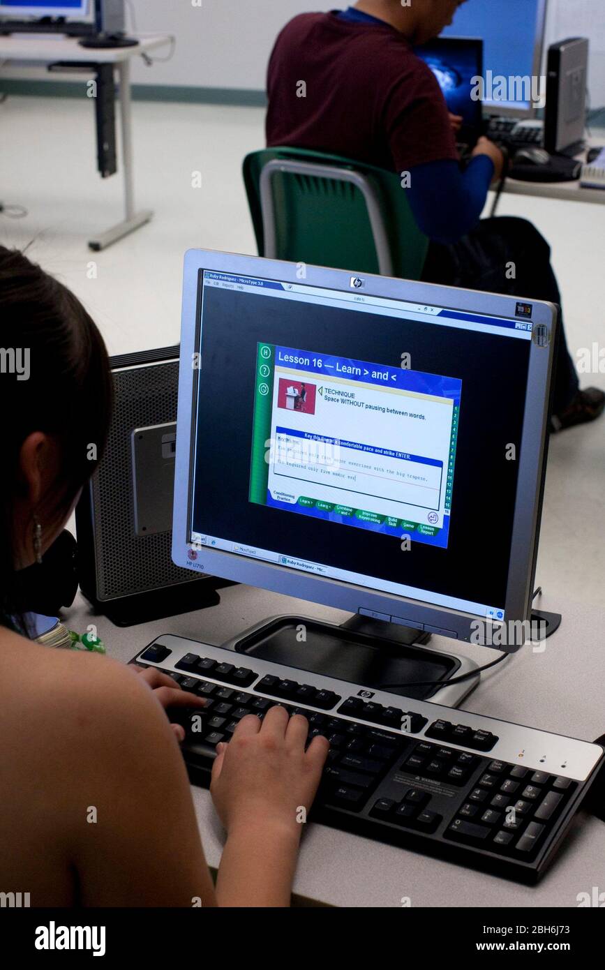 El Paso, Texas 28 mai 2009: Jeune fille dactylographiant sur clavier dans un laboratoire informatique à l'école secondaire Mission Early College dans le district scolaire Socorro d'El Paso. Les étudiants motivés de l'école hispanique majoritaire peuvent obtenir un diplôme d'associé au El Paso Community College tout en étudiant pour leur diplôme d'études secondaires dans le programme. ©Bob Daemmrich Banque D'Images