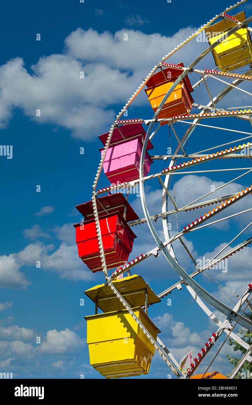 Sièges colorés à Ferris Wheel sur Blue Sky Banque D'Images