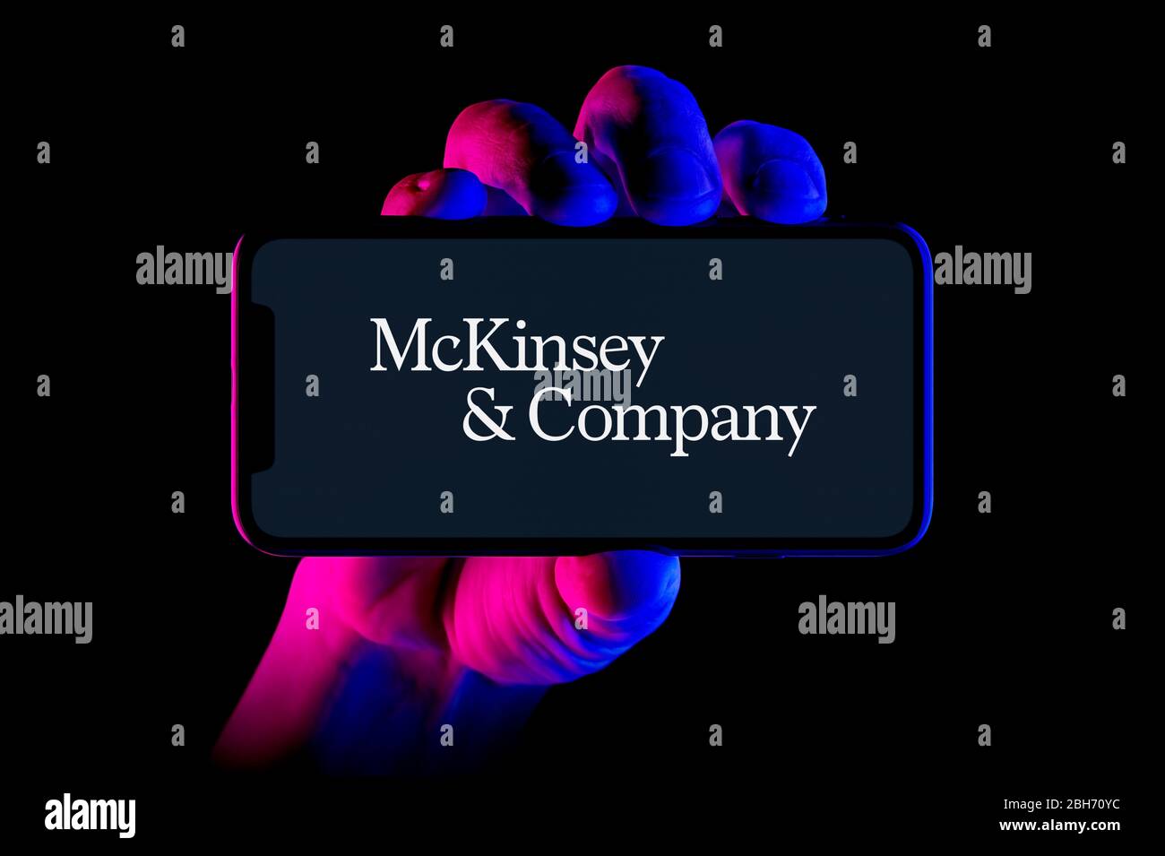 Un smartphone affichant le logo McKinsey & Company est placé sur un fond noir (usage éditorial uniquement). Banque D'Images