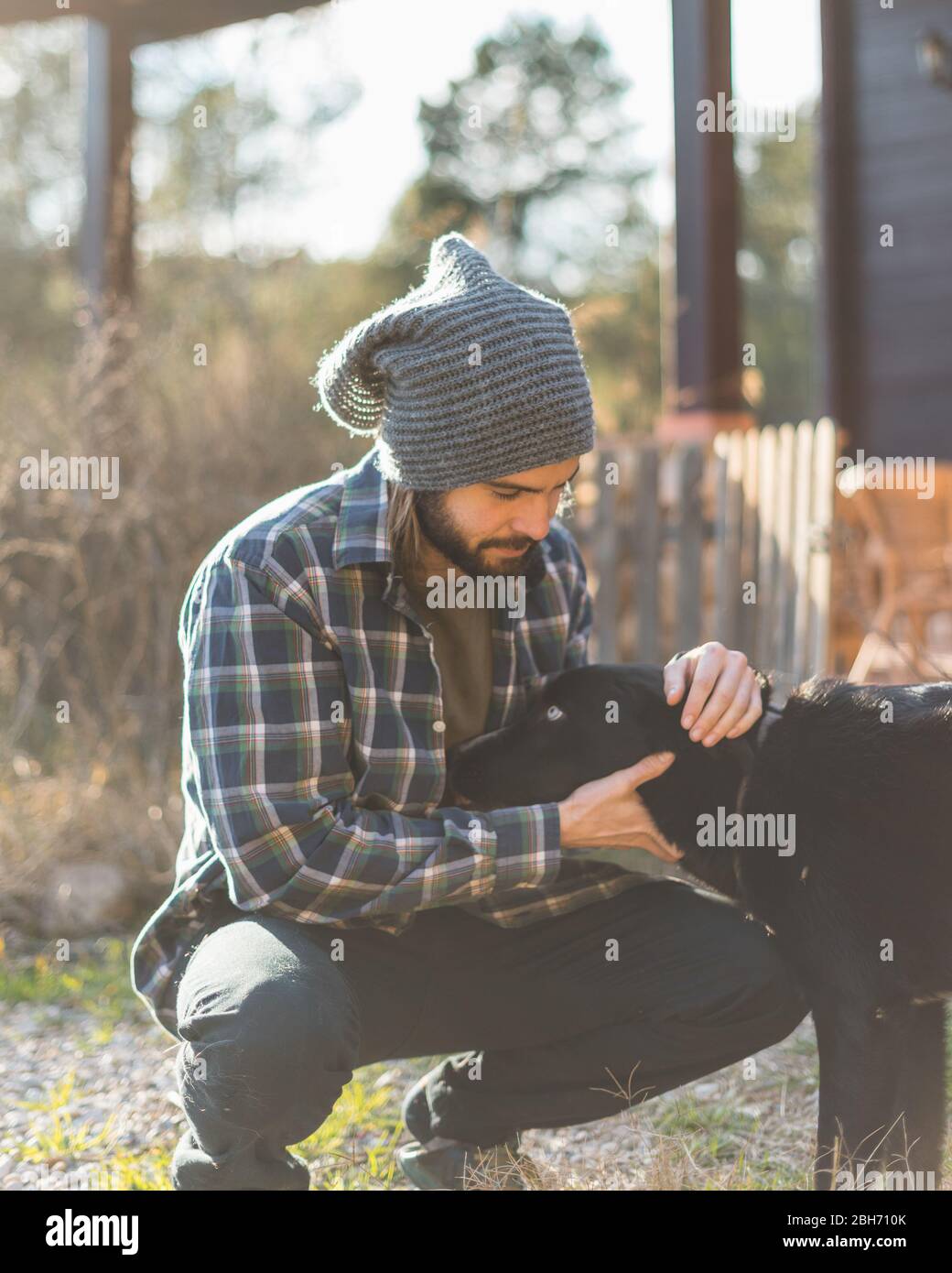 Portrait d'un homme barbu avec son vieux chien et un beau coucher de soleil sur la montagne Banque D'Images