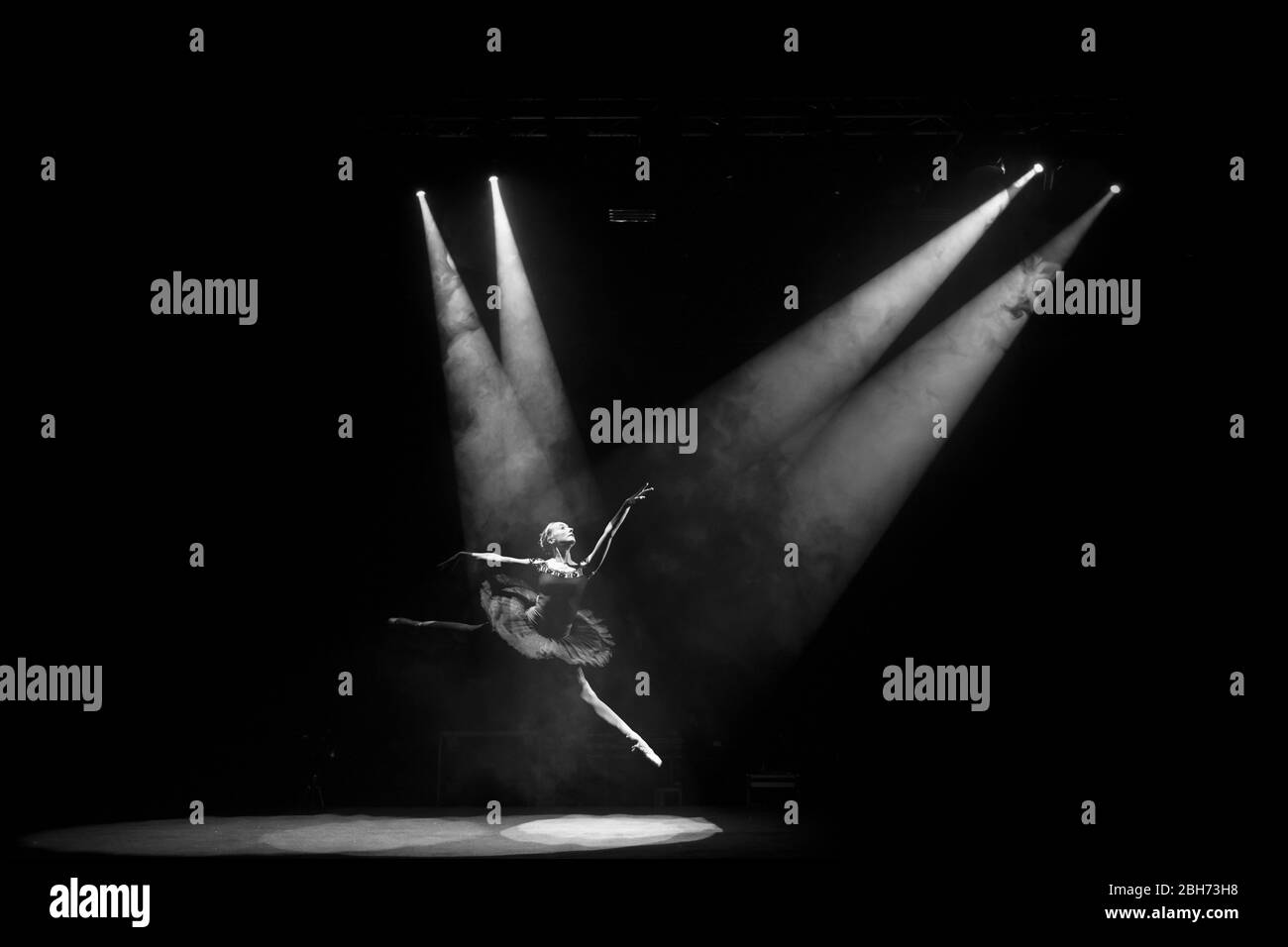 Ballerina Ballet dancer sautant sur scène avec le noir et blanc de projecteur Banque D'Images