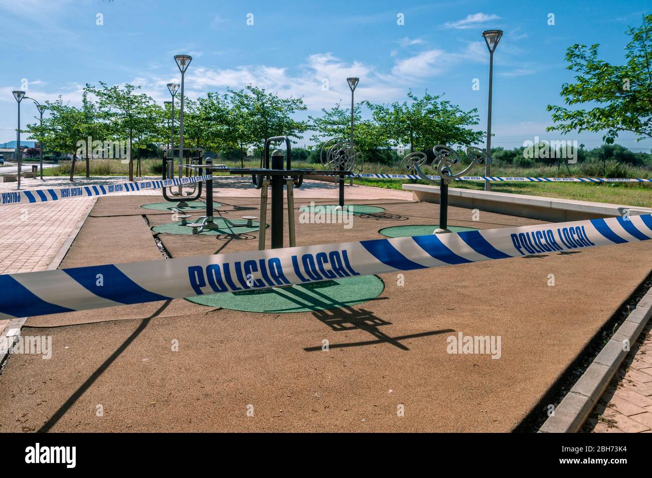 Parc public scellé par un cordon de police, le jour ensoleillé, en raison de la quarantaine pour l'épidémie de Coronavirus Banque D'Images