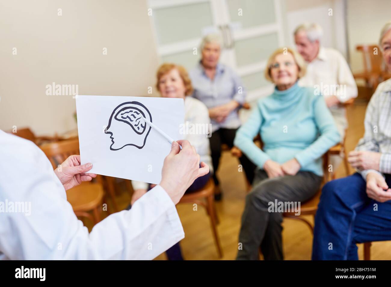 Le président avec un dessin du cerveau explique la maladie d'Alzheimer aux aînés Banque D'Images