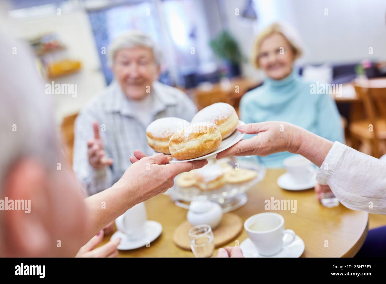 Les aînés mangent des crêpes fraîches à Berlin dans la salle commune de la maison de retraite Banque D'Images