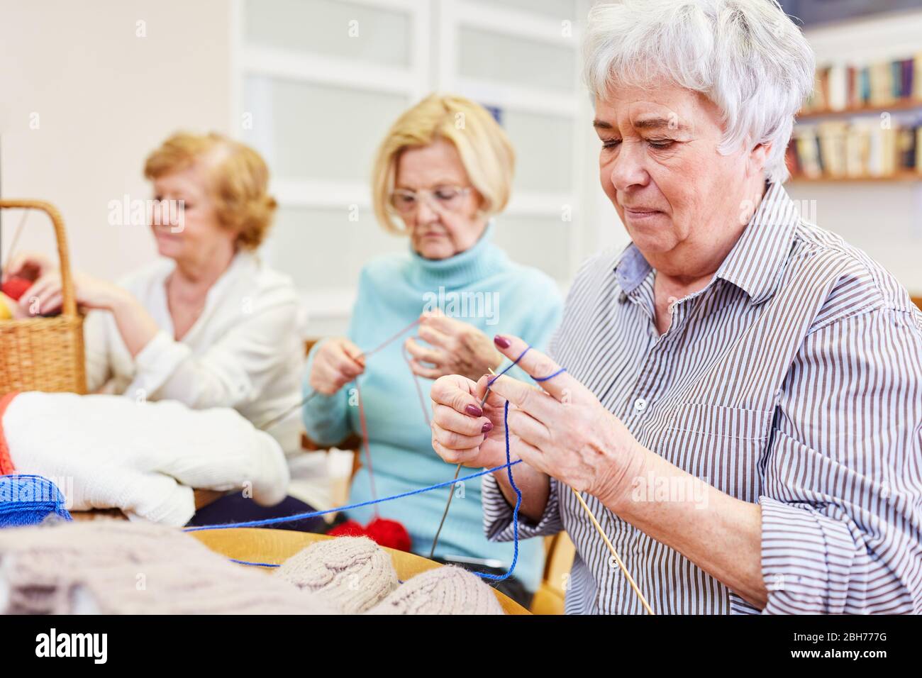 Les aînés se sont rassemblés dans un cours d'artisanat dans une maison de retraite Banque D'Images