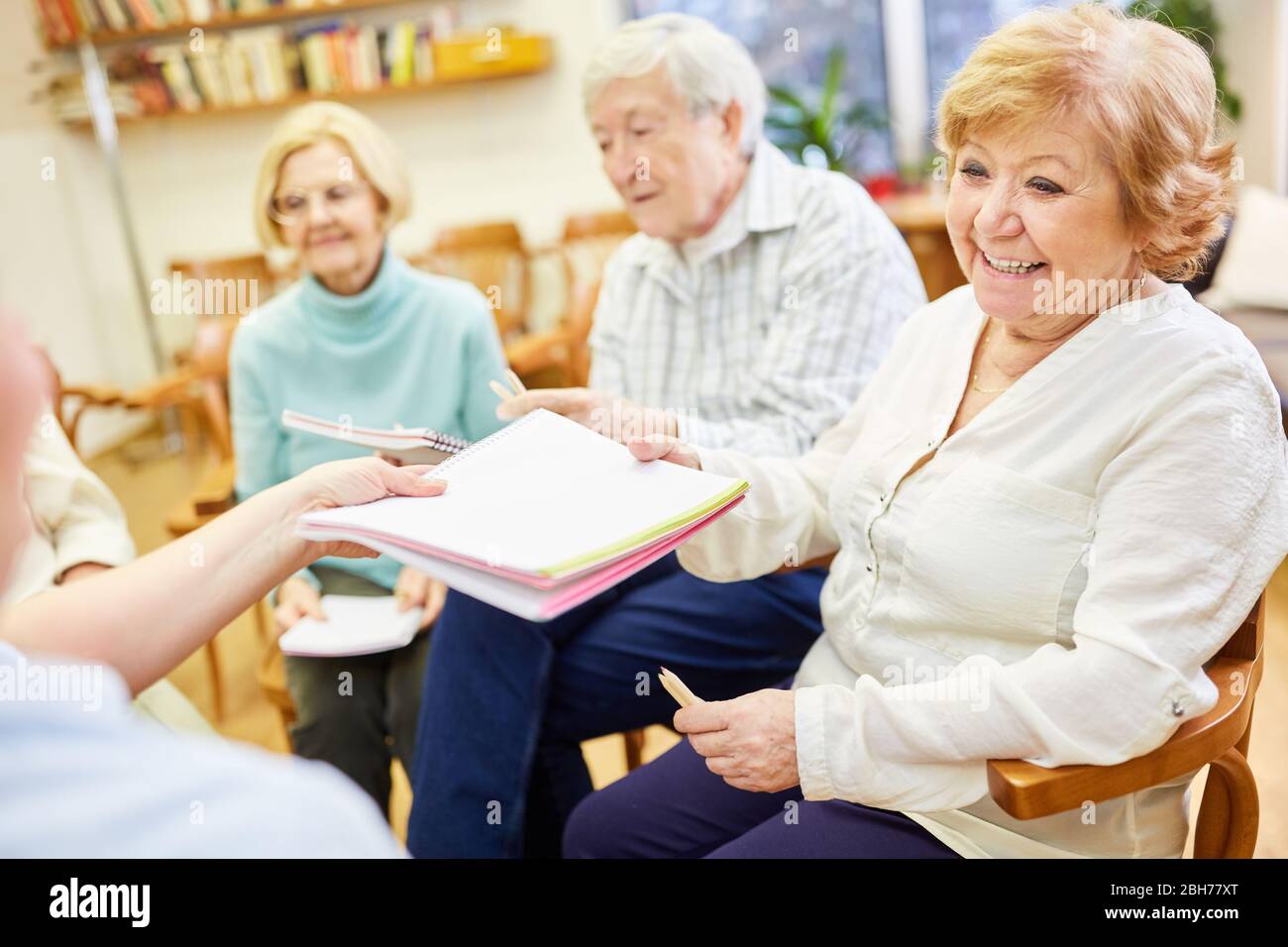 Groupe d'aînés dans une maison de soins infirmiers dans un traitement de peinture avec un bloc de dessin ou du papier Banque D'Images