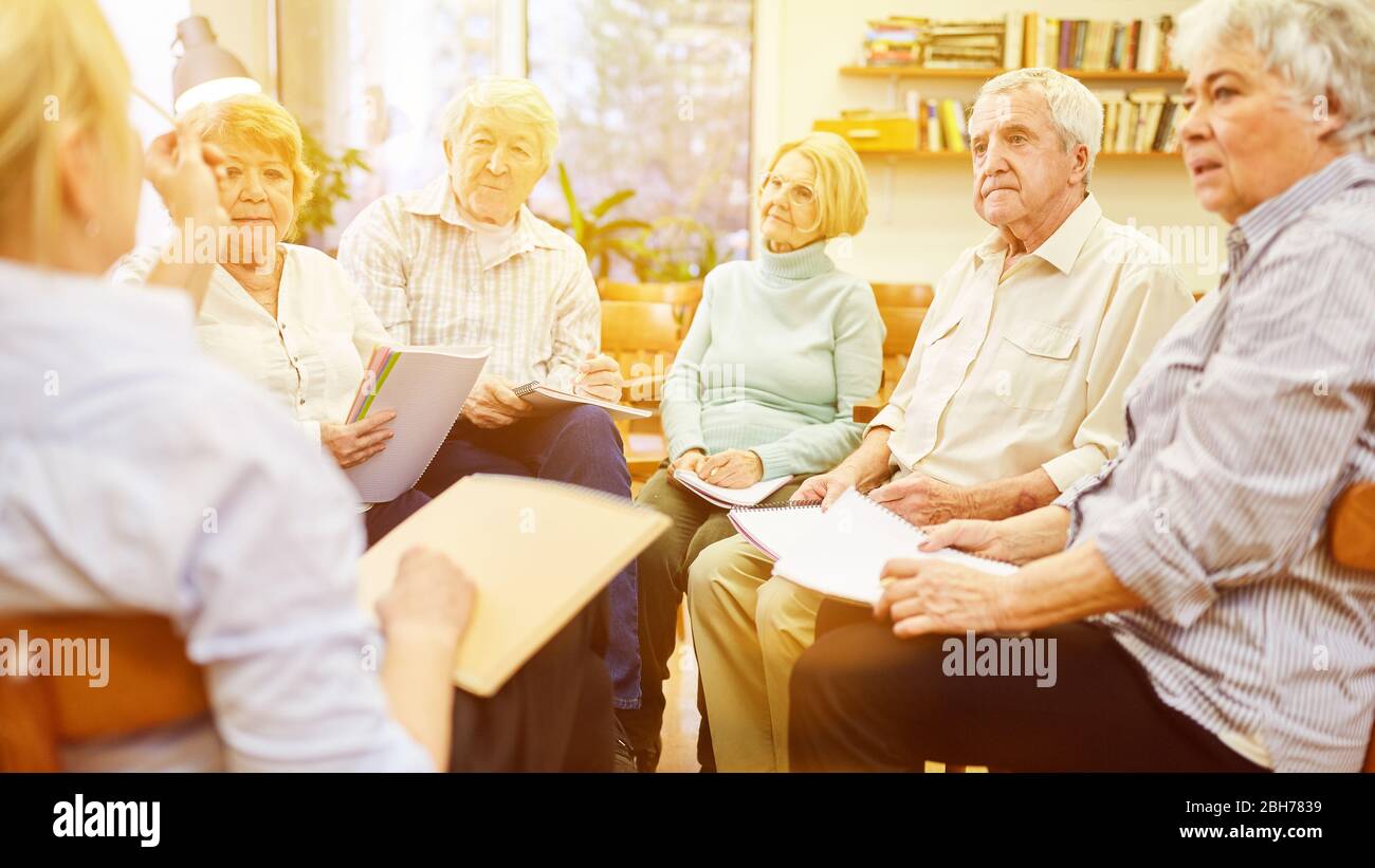 Groupe d'aînés s'entretient les uns avec les autres au groupe de discussion dans la maison des personnes âgées Banque D'Images