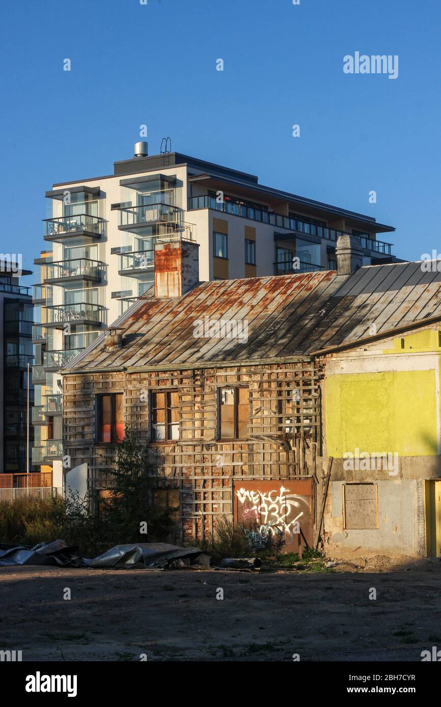 Vieux bâtiment laitier délabré devant la maison d'appartement neuve. Le gaspillage se transforme en quartier résidentiel à Järvenpää, en Finlande. Banque D'Images