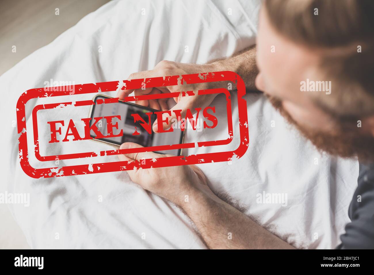 Fausses nouvelles infodemics pendant le concept de pandémie de Covid-19. Les mains de l'homme tenant le téléphone mobile lire les nouvelles mondiales ou le réseau social à la maison. Lire la dernière actualité Banque D'Images