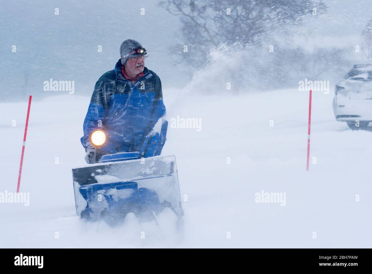 Directeur d'installation à cheval sur un souffleur de neige dans un blizzard lourd dans le nord de la Norvège Banque D'Images