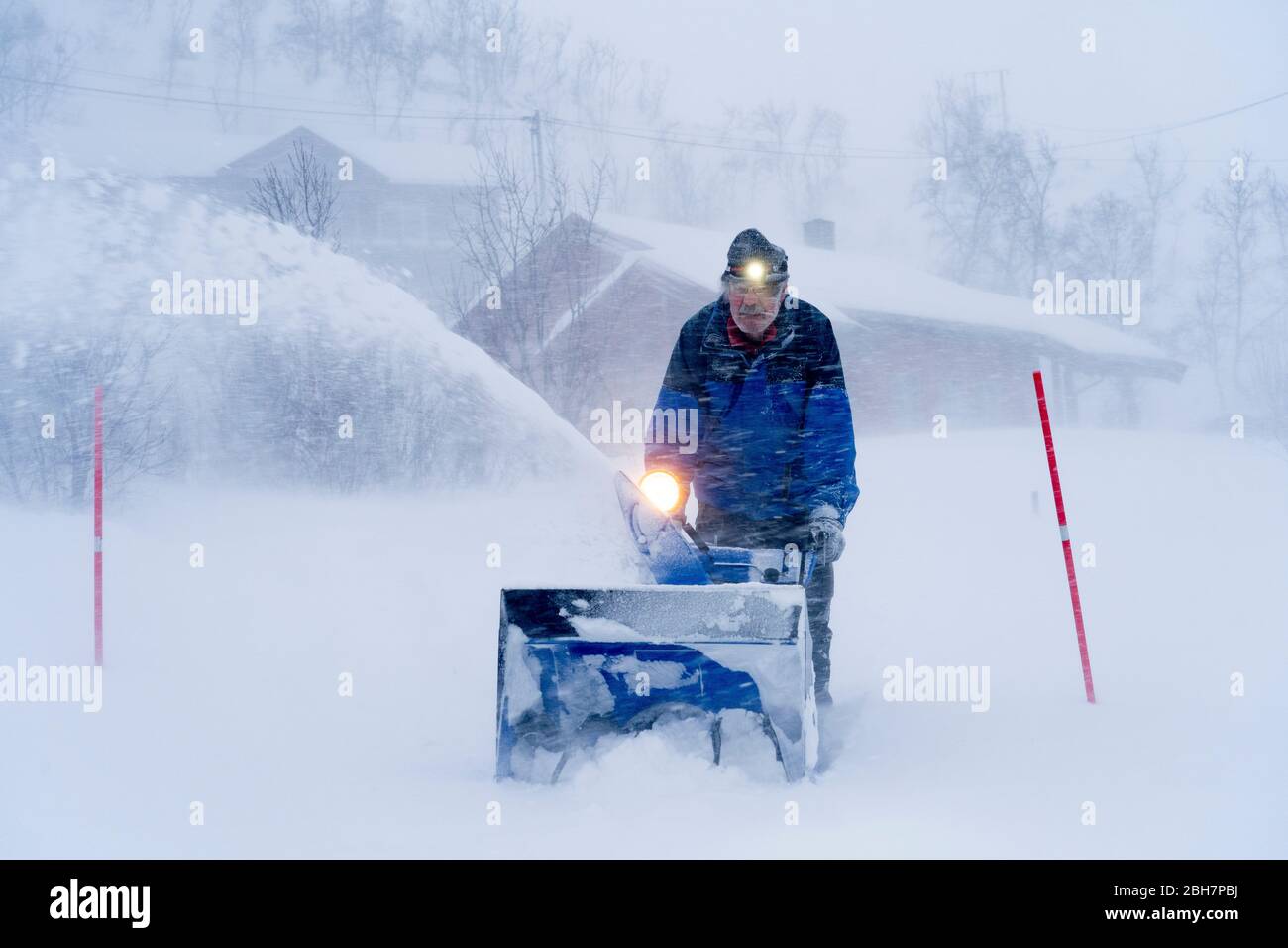 Directeur d'installation à cheval sur un souffleur de neige dans un blizzard lourd dans le nord de la Norvège Banque D'Images