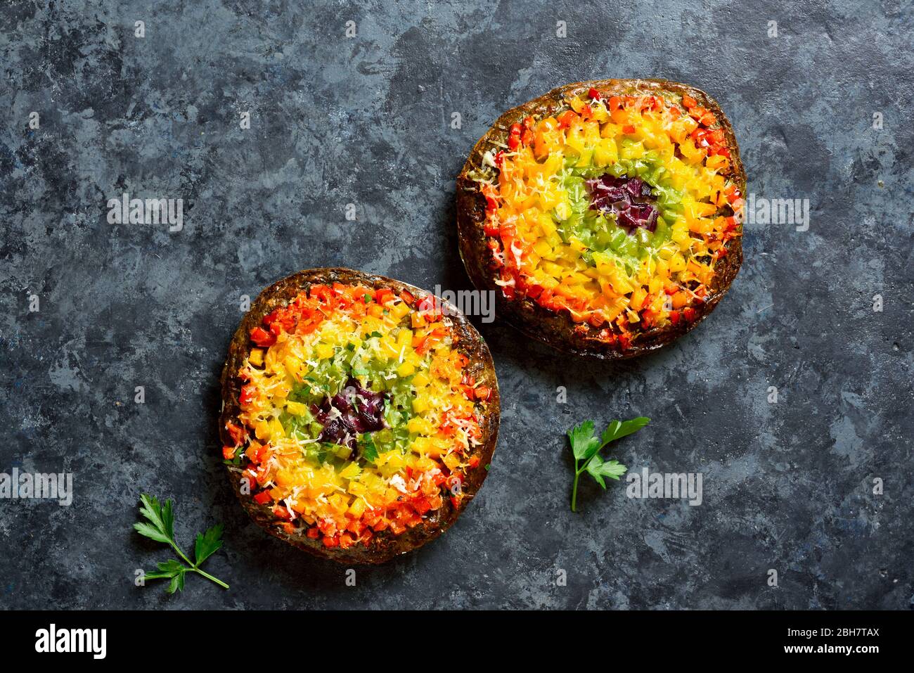 La cloche de légumes Rainbow piments pizza croûte sur fond de pierre bleue avec espace texte libre. Concept de cuisine végétarienne. Vue sur le dessus, plat Banque D'Images