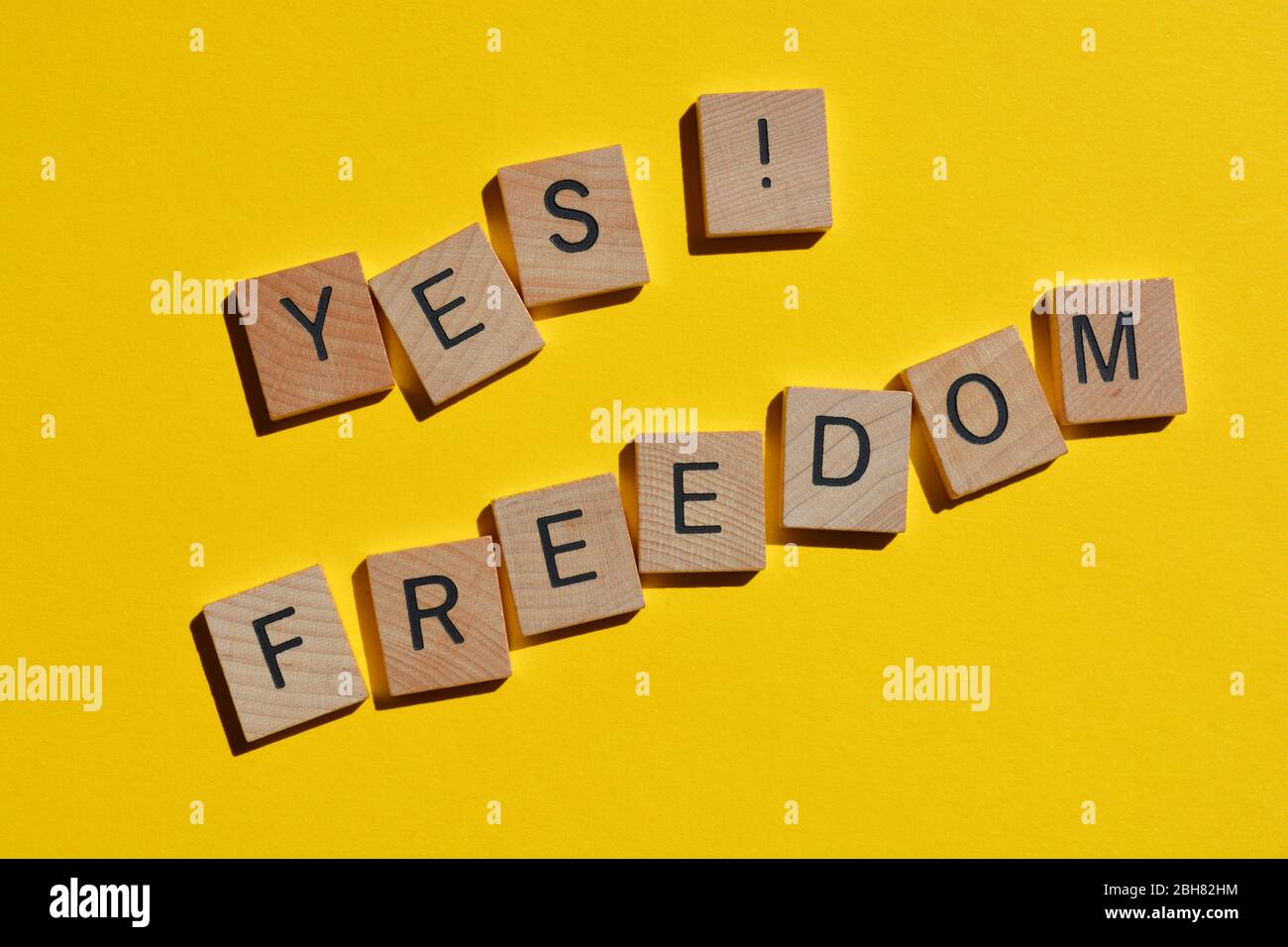 Oui, liberté, mots en lettres de bois isolés sur jaune Banque D'Images