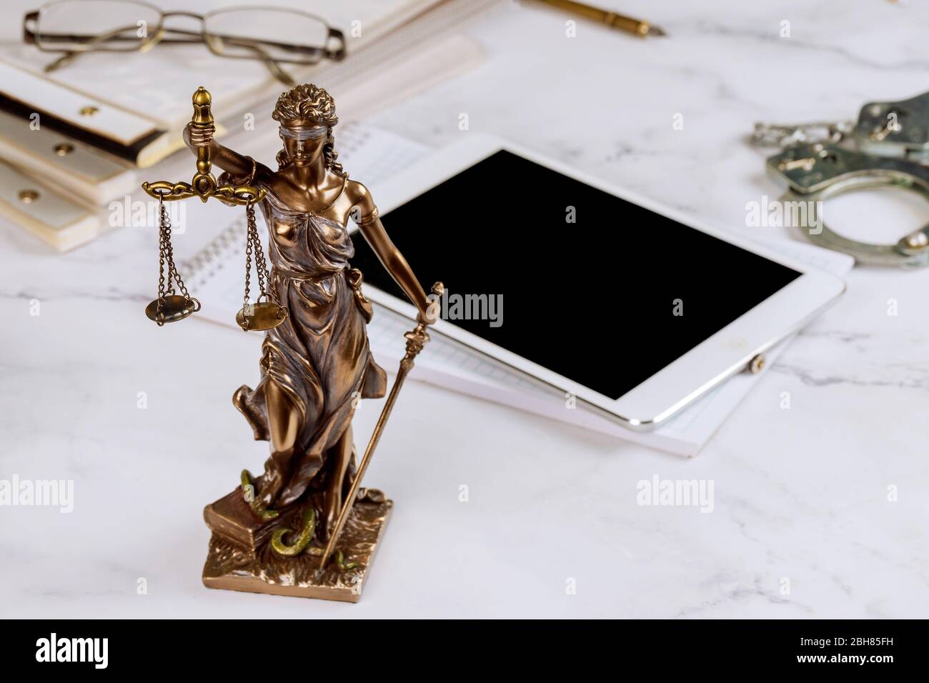 Avocat Statue de la justice avec des avocats de balance symboles bureau travaillant sur une tablette numérique Banque D'Images