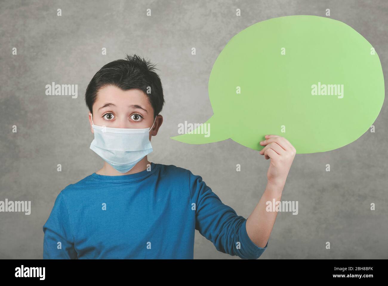 Enfant portant un masque médical avec bulle de la parole sur fond gris Banque D'Images