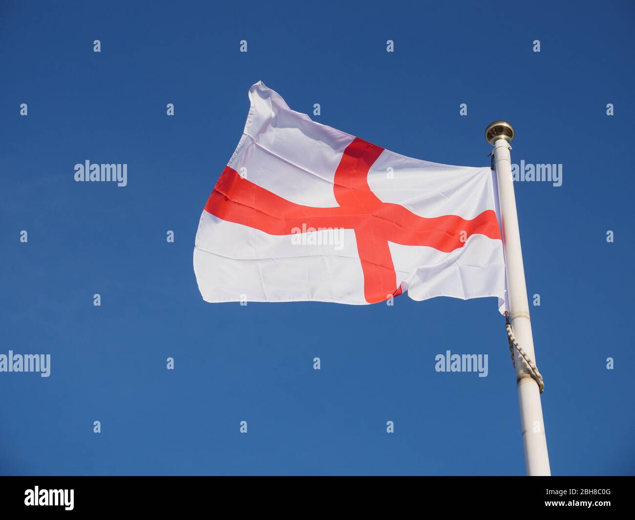 Drapeau de St George volant contre un ciel bleu d'été glorieux, Angleterre, Royaume-Uni. Banque D'Images