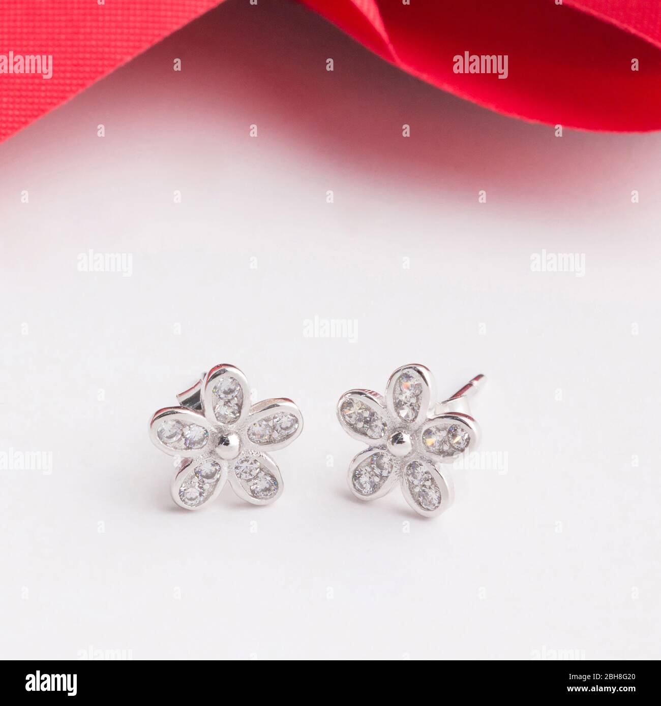 Une paire de superbes boucles d'oreilles en argent 925 en forme de fleur décorent avec du zircone cubique isolé sur fond blanc Banque D'Images