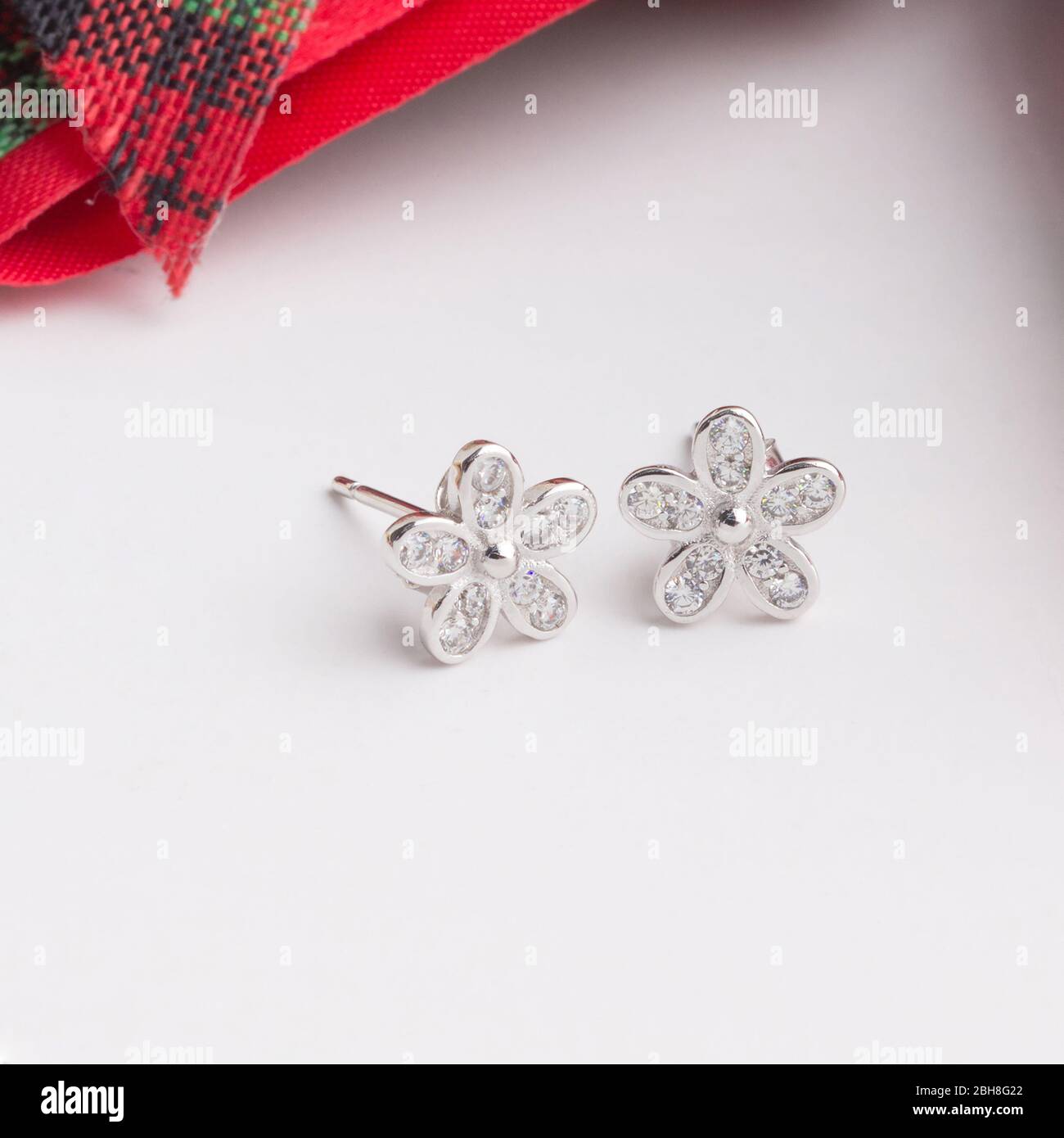 Une paire de superbes boucles d'oreilles en argent 925 en forme de fleur décorées de zircone cubique isolé sur fond blanc Banque D'Images