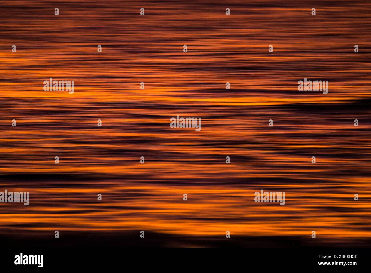 Image floue artistique avec de l'eau rouge de l'océan et qui s'étendait des temps d'exposition avec le mouvement - arrière-plan parfait pour l'eau et le coucher du soleil concept Banque D'Images