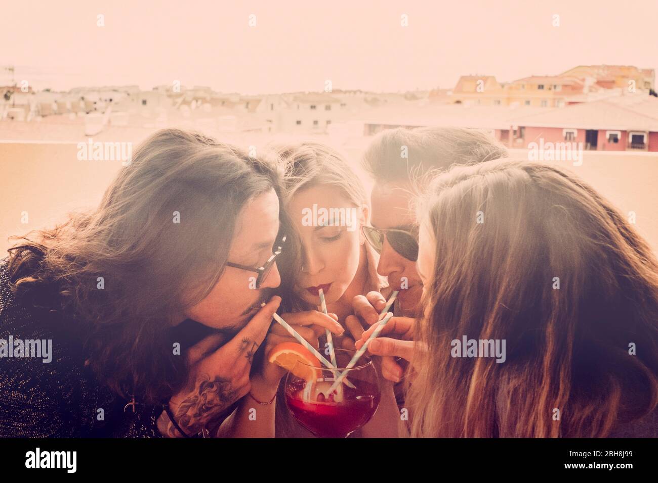 Groupe d'amis deux couples hommes et femmes célèbrent et s'amuser ensemble boire du même verre - fête en l'amitié pour les caucasiens - nouvelle année de célébration en plein air Banque D'Images
