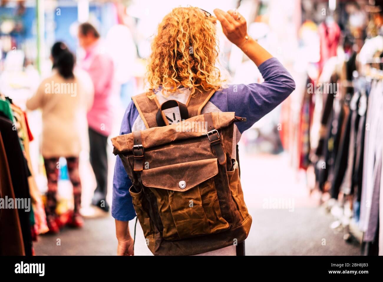 Femme blonde cheveux cally voyageur routard vue de l'arrière sur le marché  d'occasion profiter des magasins et des vacances alternatives - cuir sac à  dos vue pour le concept de voyage Photo