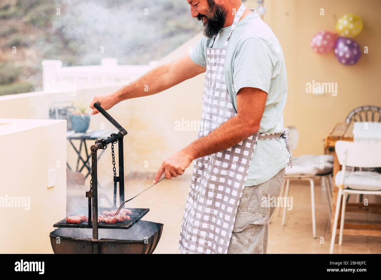 Gros plan sur les mains de l'homme cuisine de la viande fraîche sur un barbecue en bois de style ancien et feu barbecue grill - célébration maison pour les personnes aiment manger et profiter avec des amis - restaurant et la maison de cuisine et de nourriture Banque D'Images