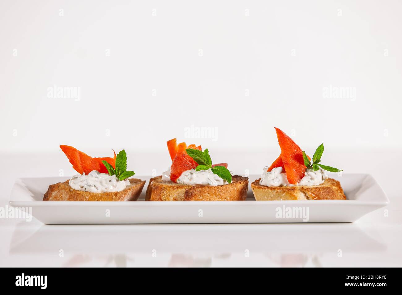 Assiette de poisson de saumon décoratif sur l'apéritif de la bruschetta Banque D'Images