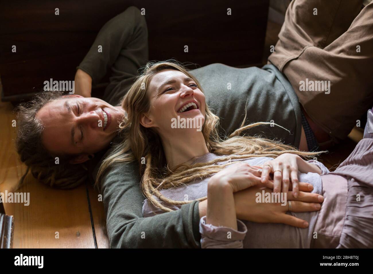 Rire vivace jeune couple amoureux couché sur le sol en face d'une vue à angle bas Banque D'Images